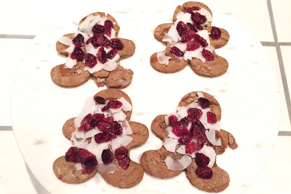 Gingerbread men cookies topped with coconut and cranberries
