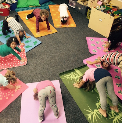 Preschoolers in yoga class doing downward facing dog pose 