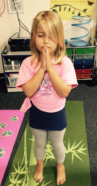 Preschool girl standing in Prayer yoga pose