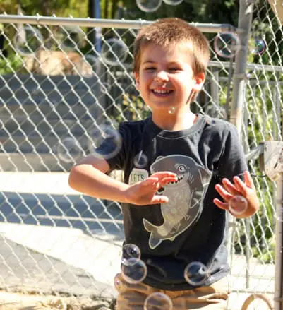 child playing with bubbles at daycare center