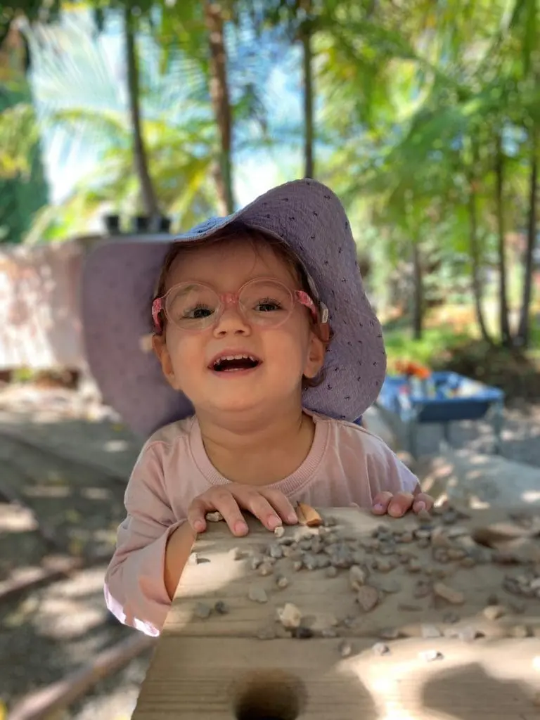 toddler smiling in nature at preschool