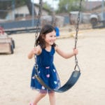 girl on swings at preschool