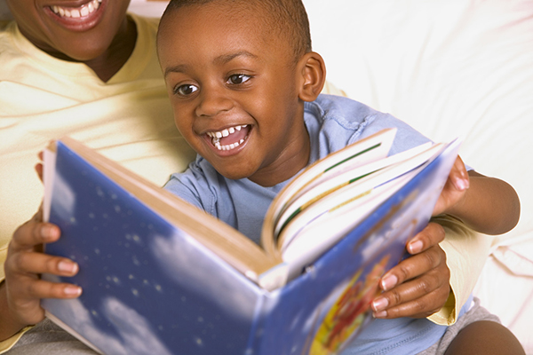 Parent reading book with young boy