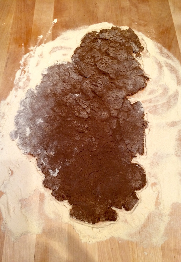Gingerbread cookie dough rolled out on floured surface