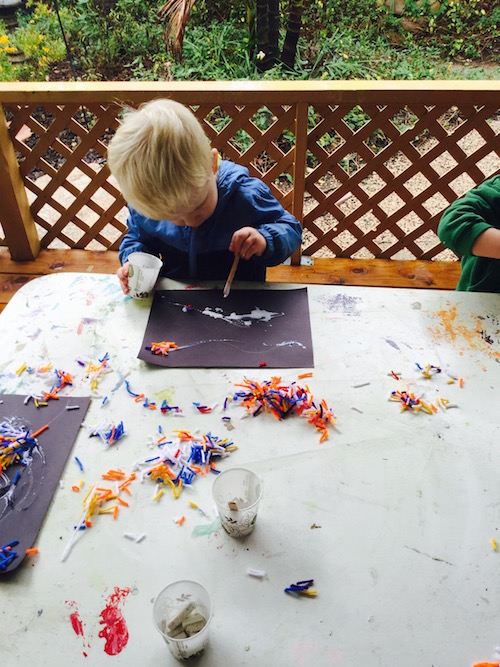 Carmel Mountain Preschool student working on rainy day art project with glue