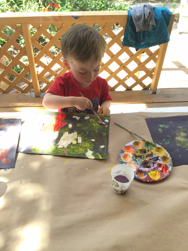 Preschool boy painting in art class
