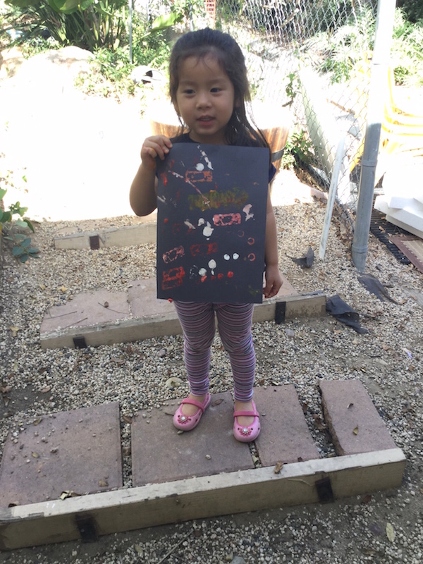Preschool girl showing paint project