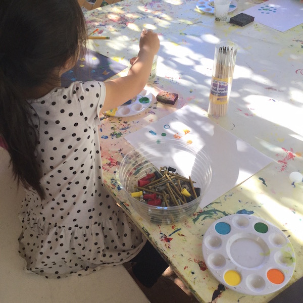 Young girl painting in art class