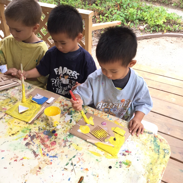 Kids painting with yellow paint