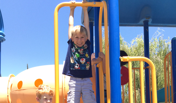 kid hanging from playground