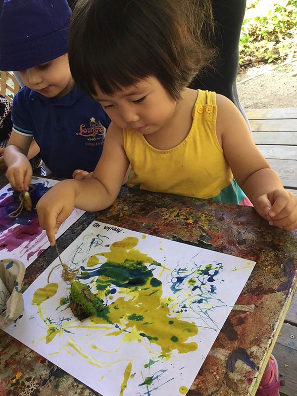 girl painting at our daycare center