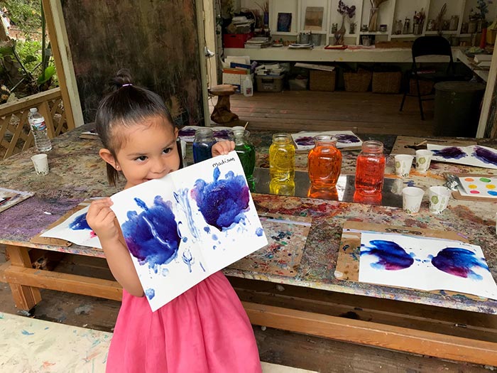 girl holding her art project at our daycare center