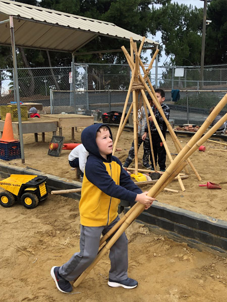 child building with wood at daycare
