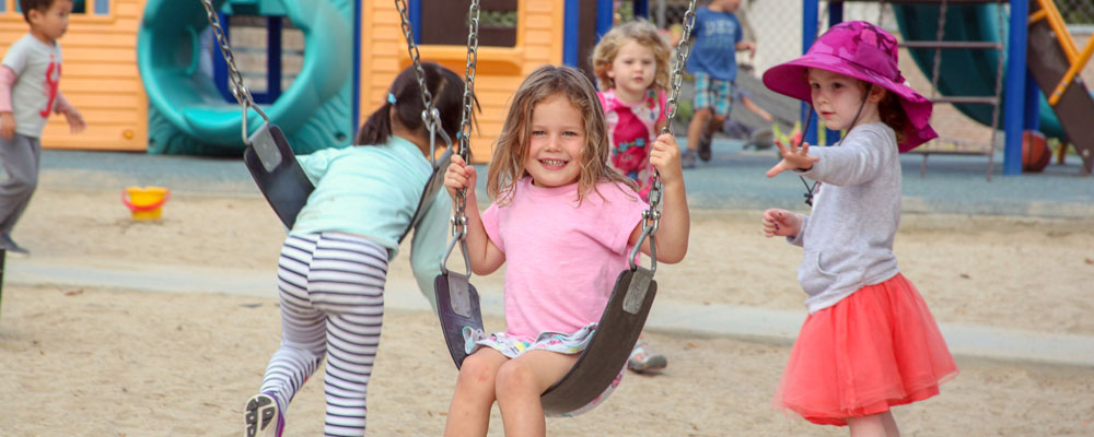 girl swinging on swing at child care center