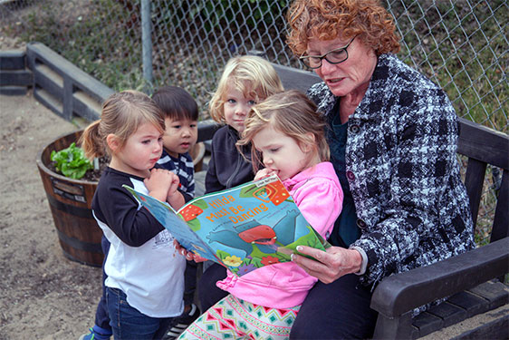 grandma reading to children at child care center
