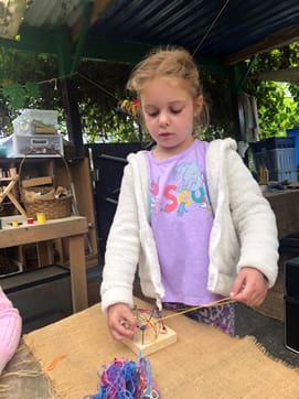 girl tying yarn at daycare