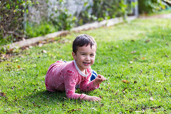 boy playing in grass at summer day care
