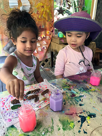 girls creating canvas art at daycare center