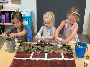 girl creating roly pollies with clay at preschool