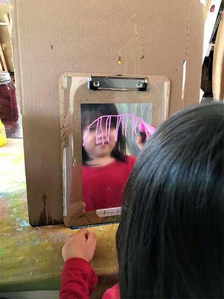 girl having fun with mirror at daycare