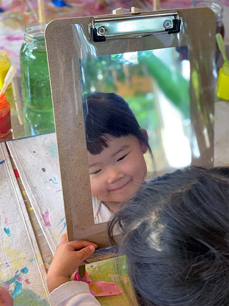 girl looking in mirror at daycare