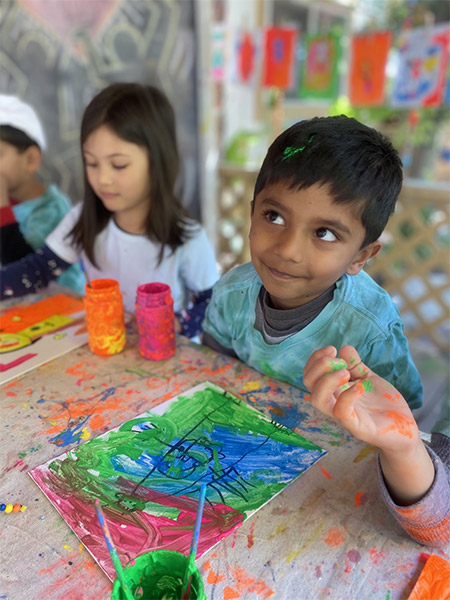 boy painting in art class at preschool