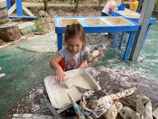 girl making paper mache outside at preschool