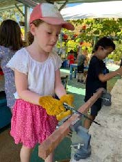 girl using saw at preschool