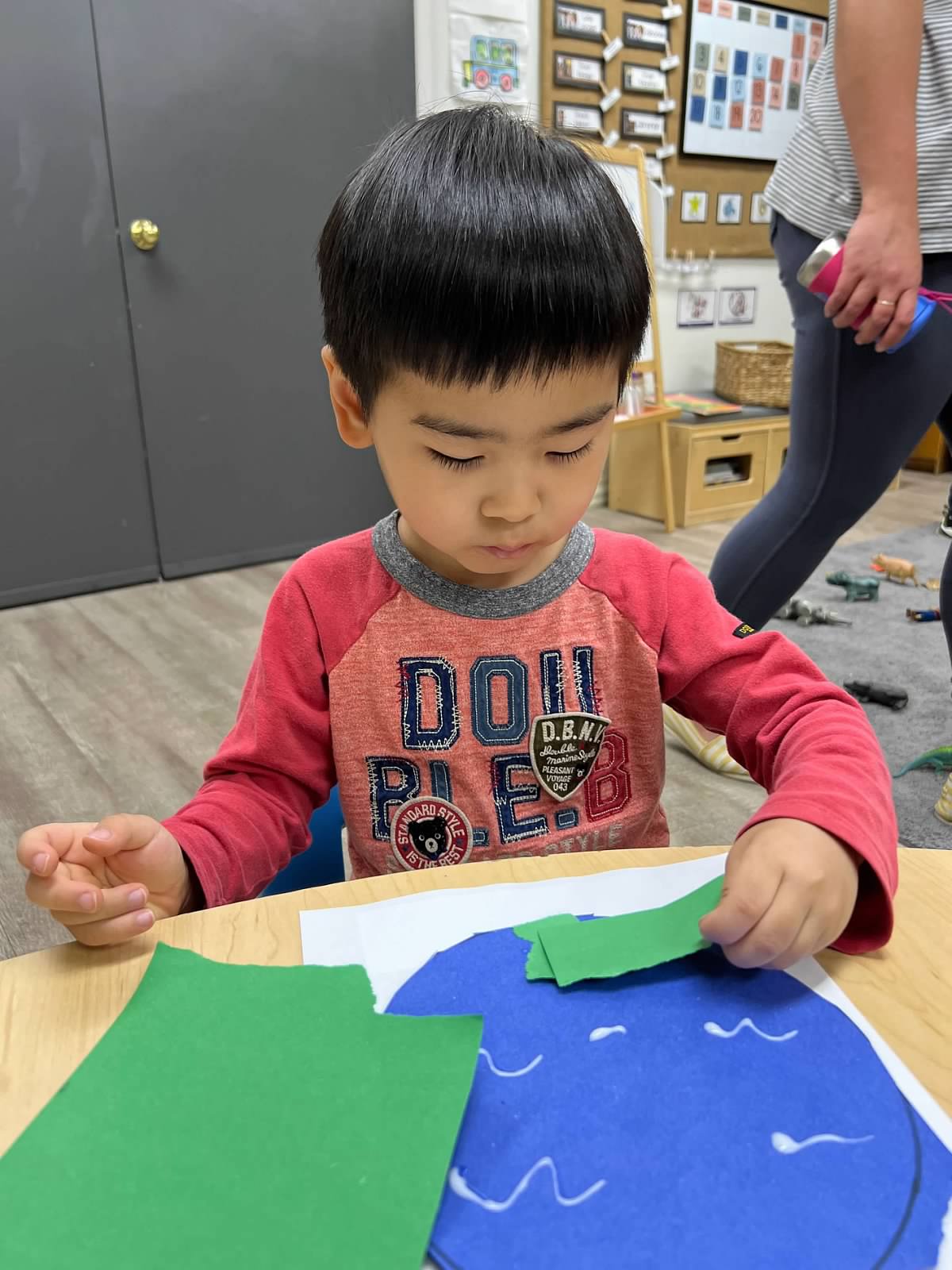 boy creating earth day crafts at preschool