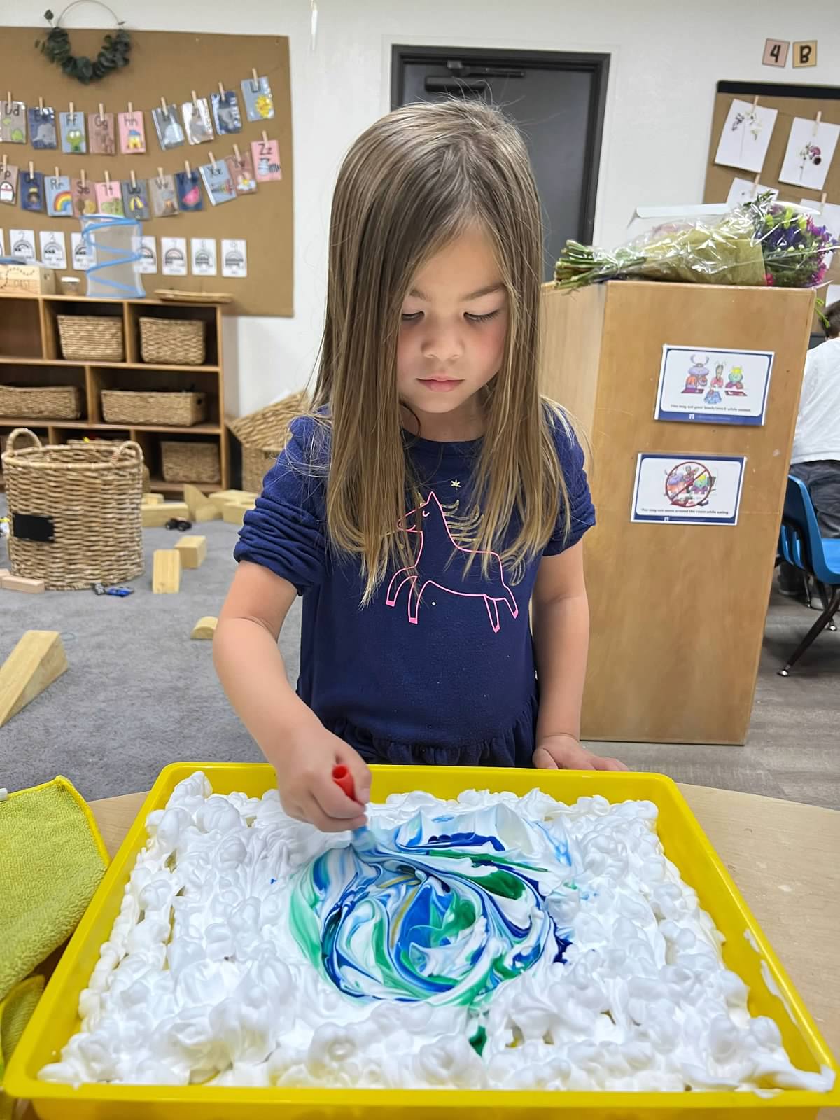 girl creating art project at preschool for earth day
