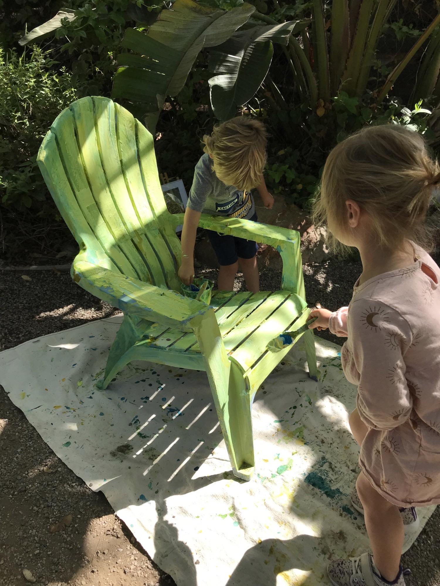 preschoolers painting chairs