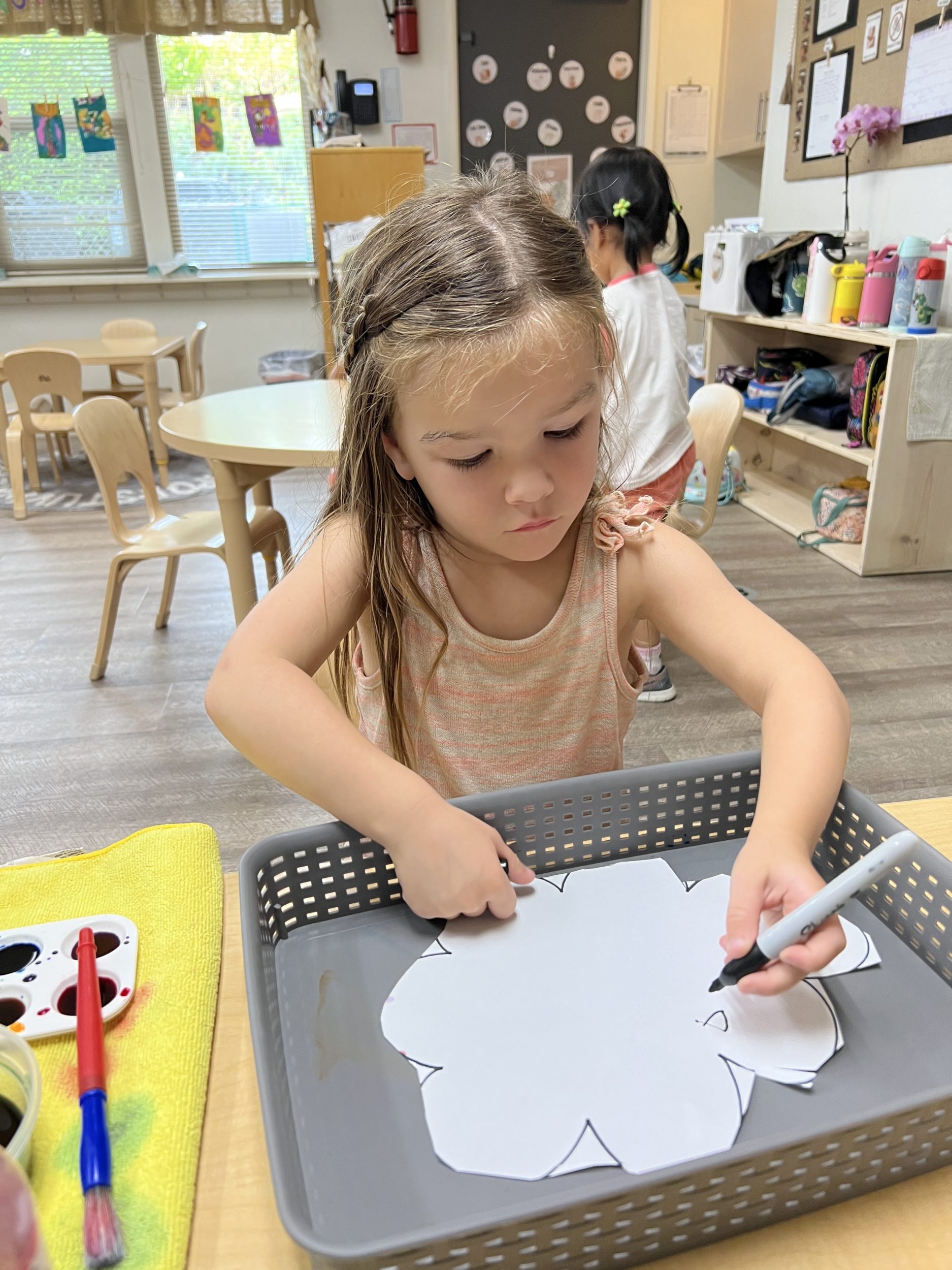 girl tracing artwork at preschool