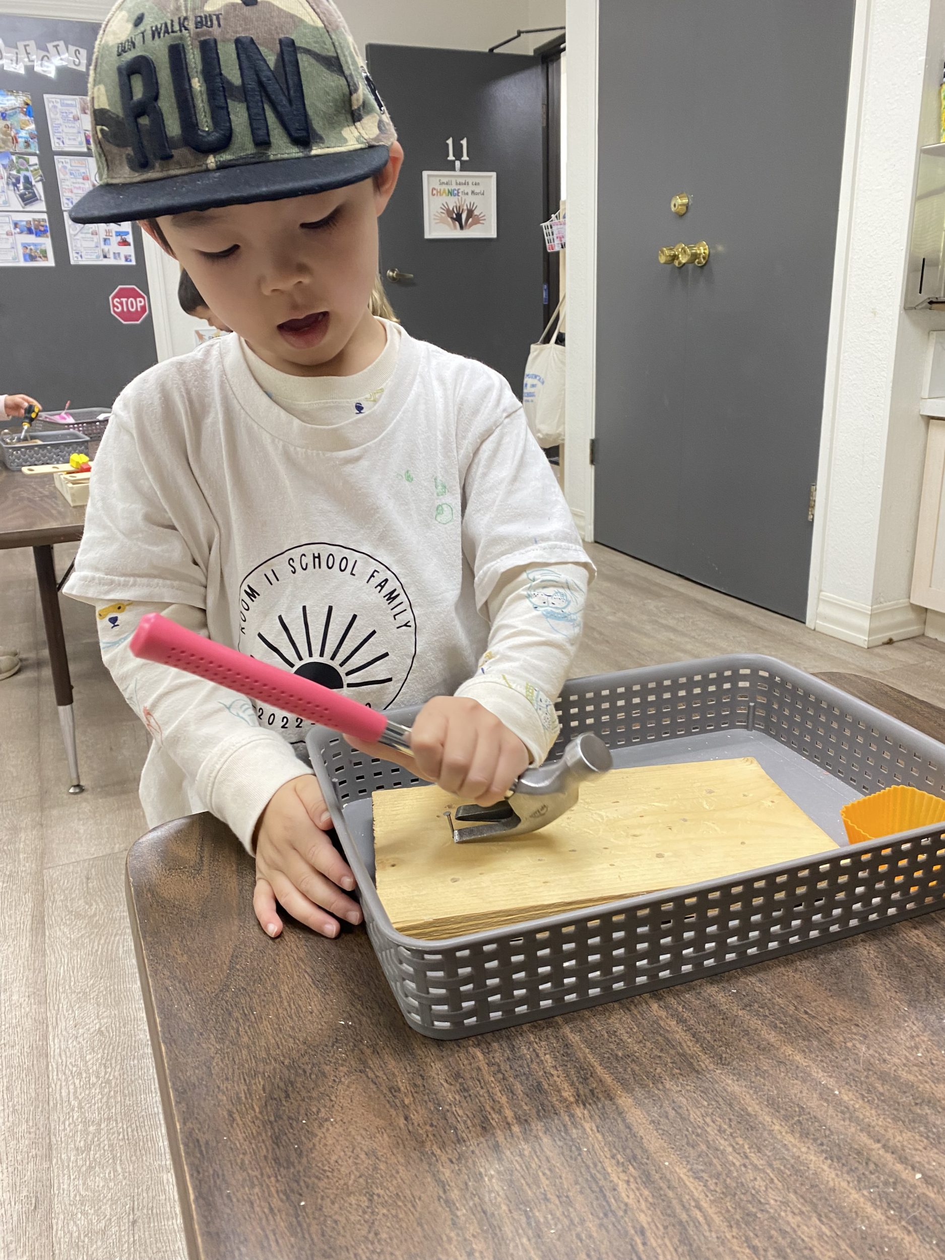 young boy using tools at preschool
