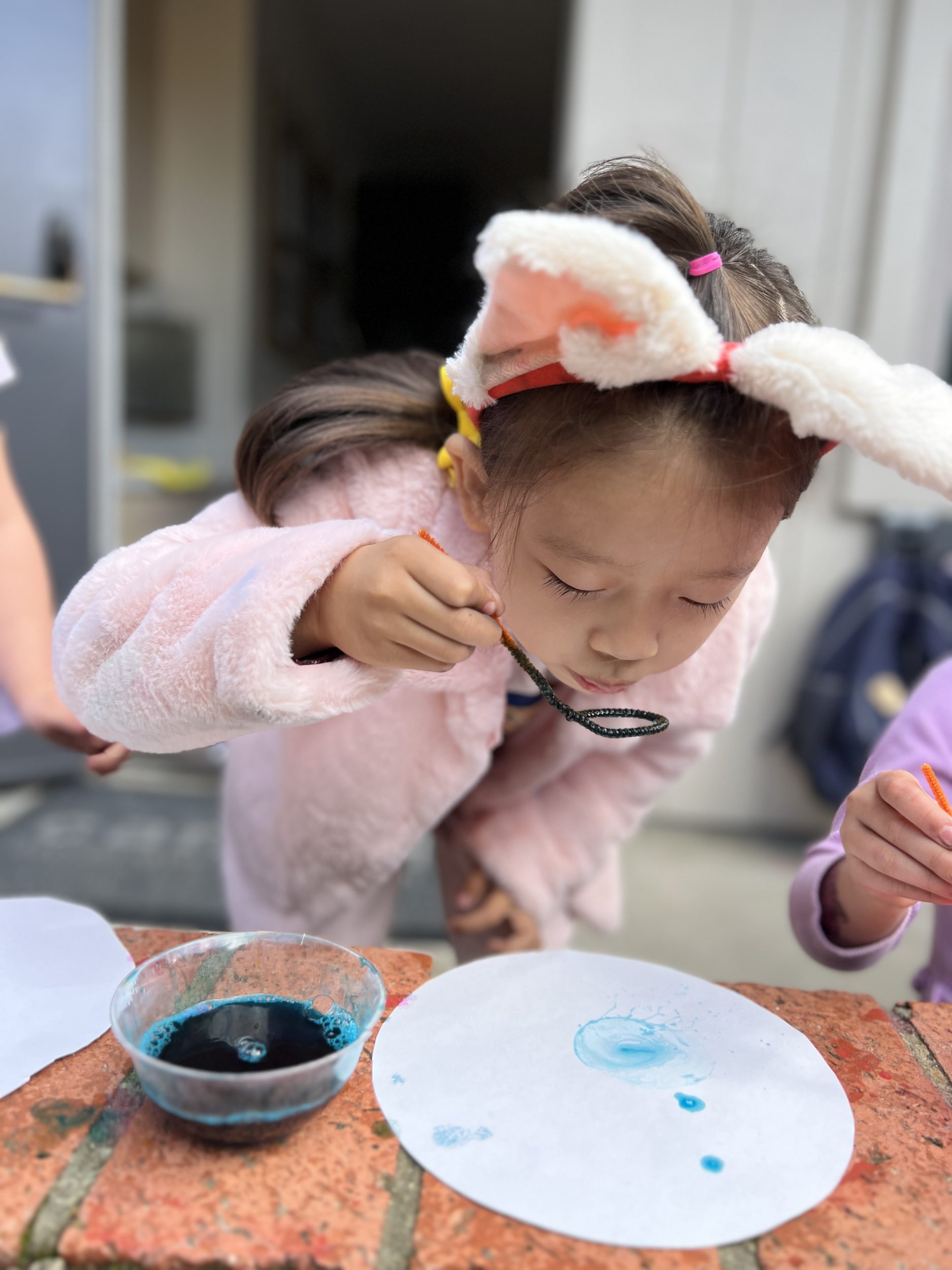 young girl doing bubble art