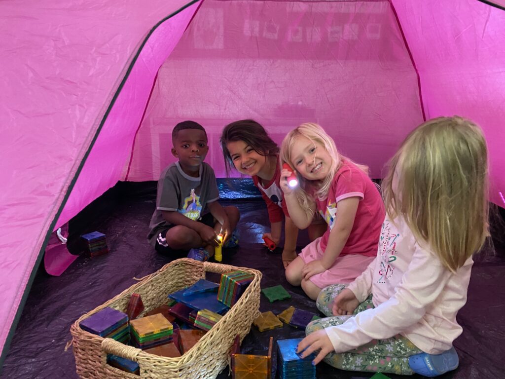 children playing games in tent at preschool