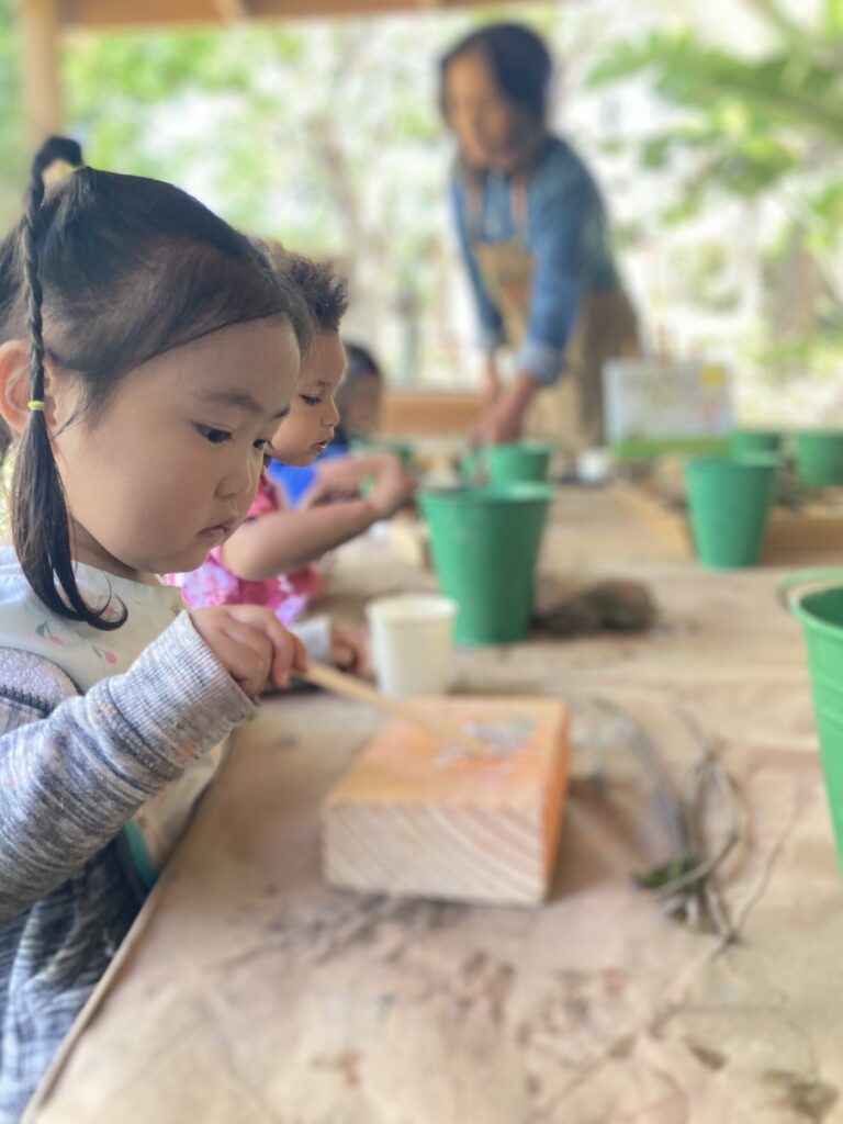 girl painting on a piece of wood