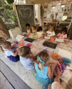 students painting at table at preschool