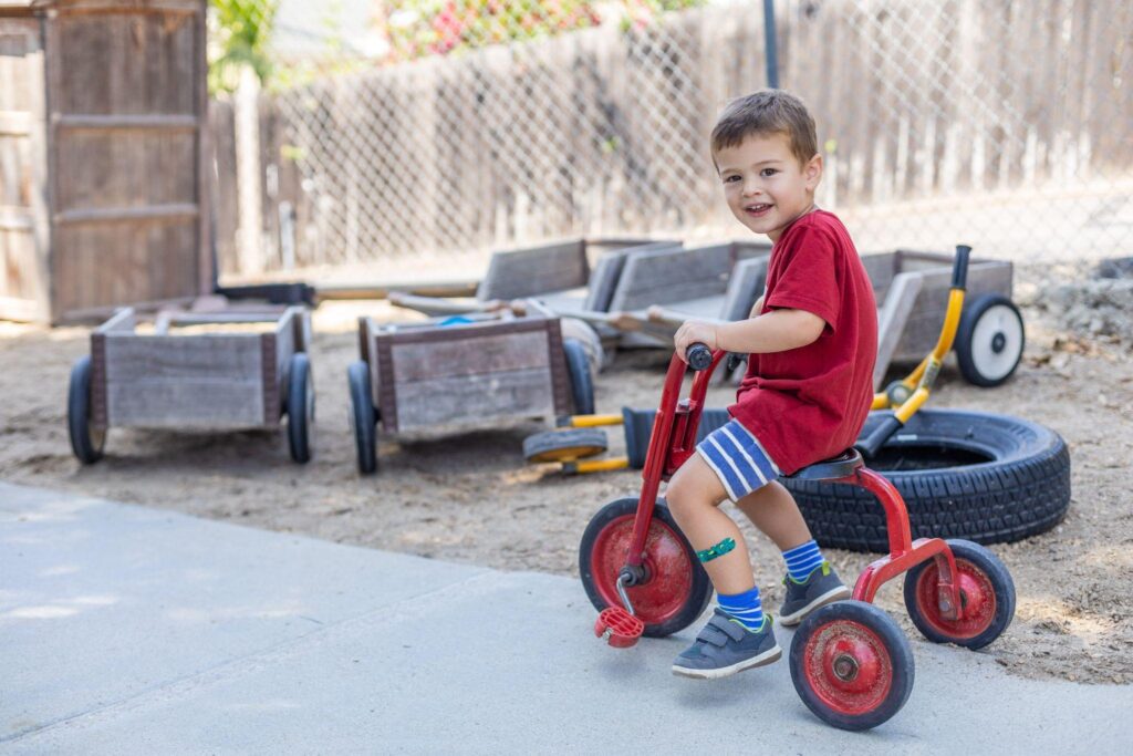 boy on tricycle at preschool