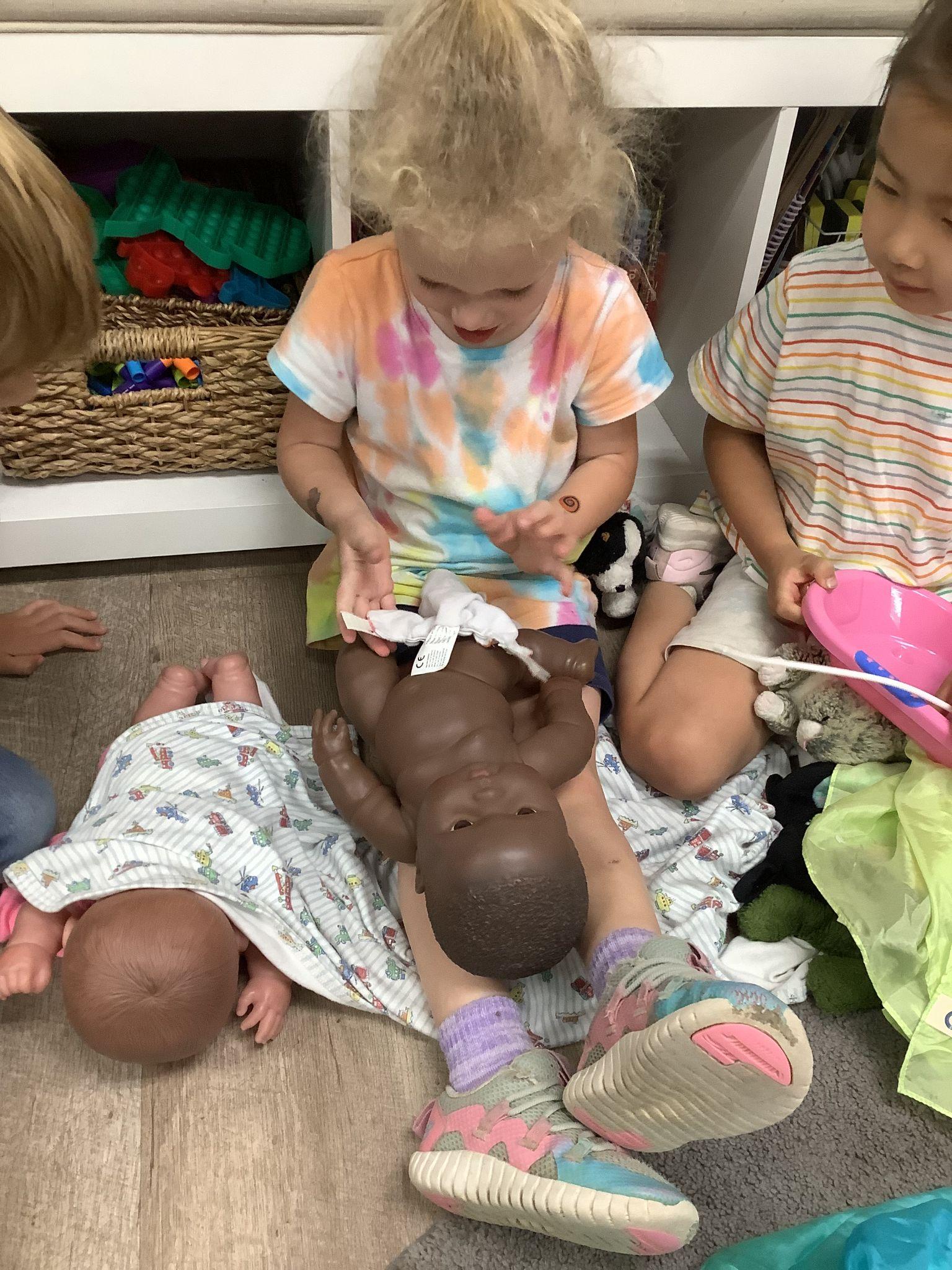 toddler learning to take care of a baby
