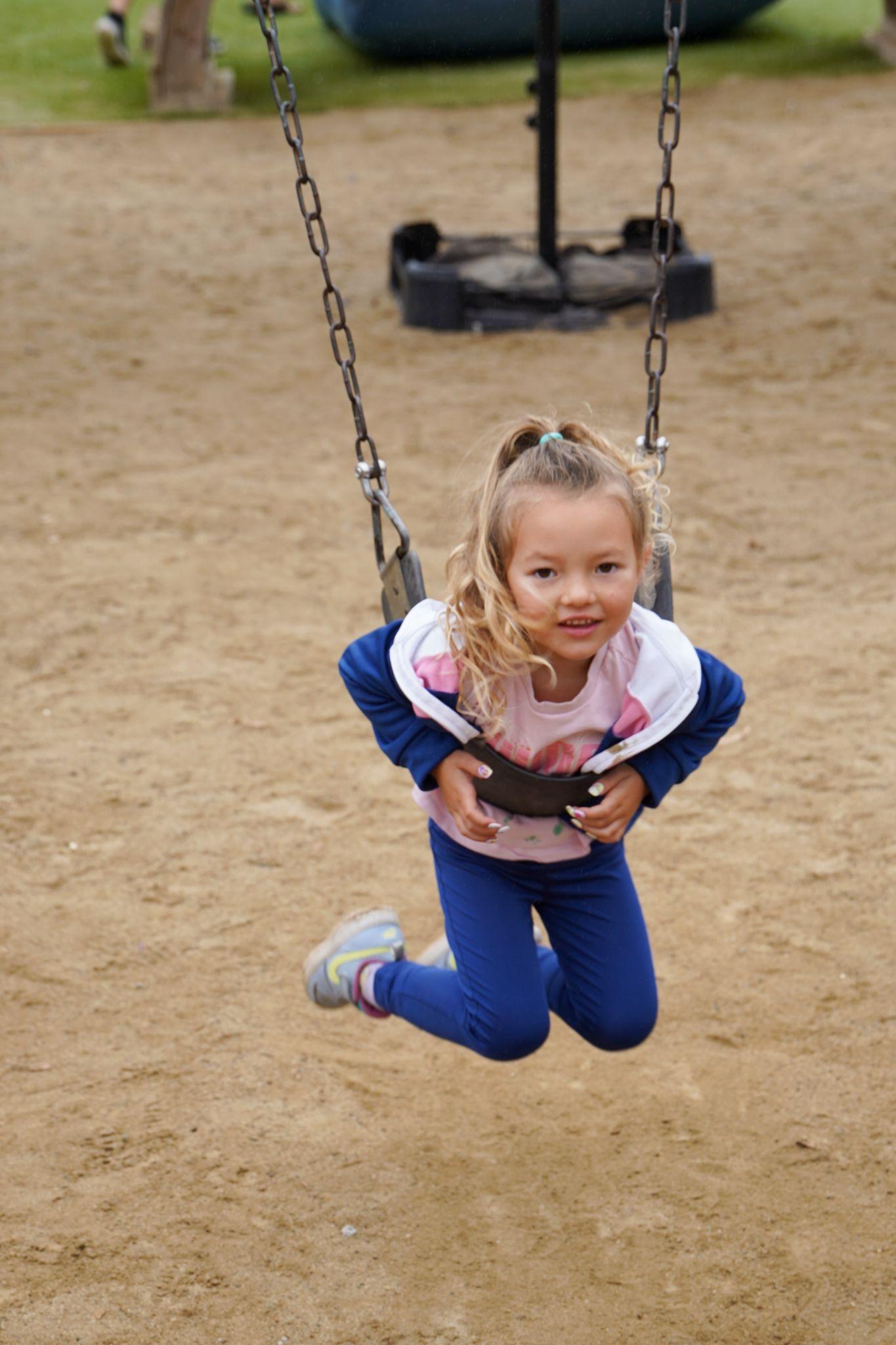 young girl on swing at preschool
