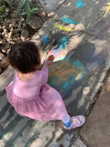 girl painting sidewalk with chalk