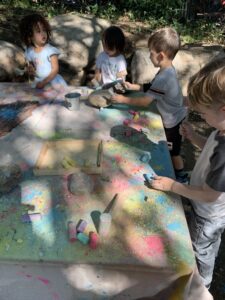 child gathered to color with chalk at preschool