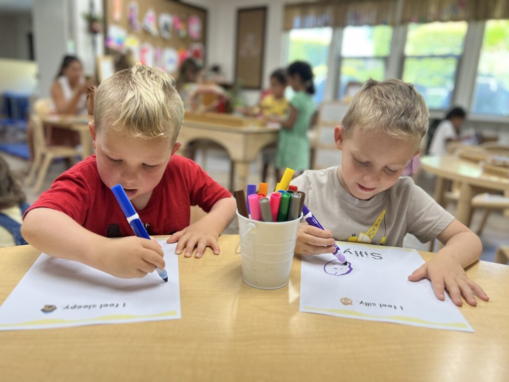 two boys at preschool writing