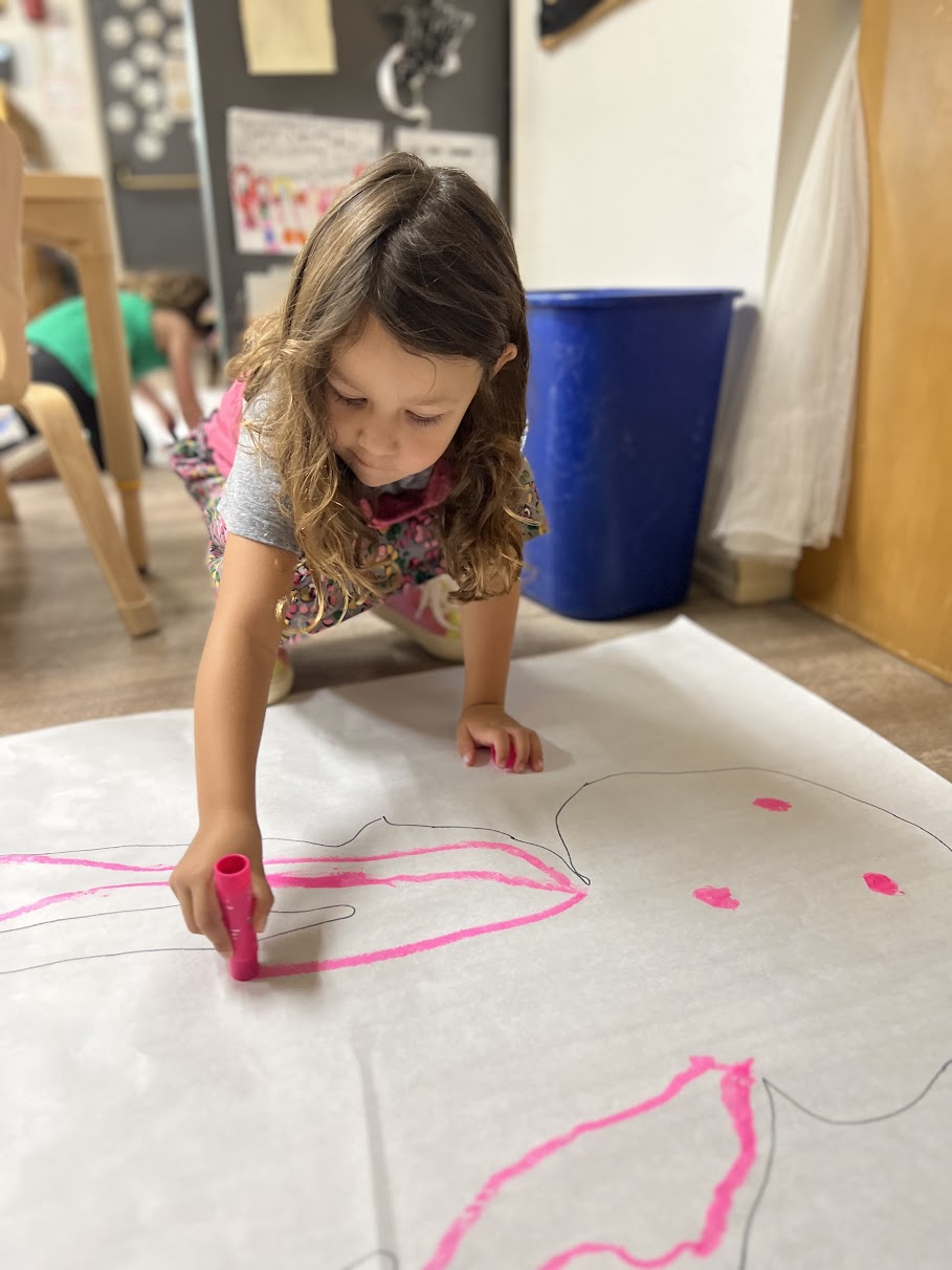 young girl painting a bunny at preschool
