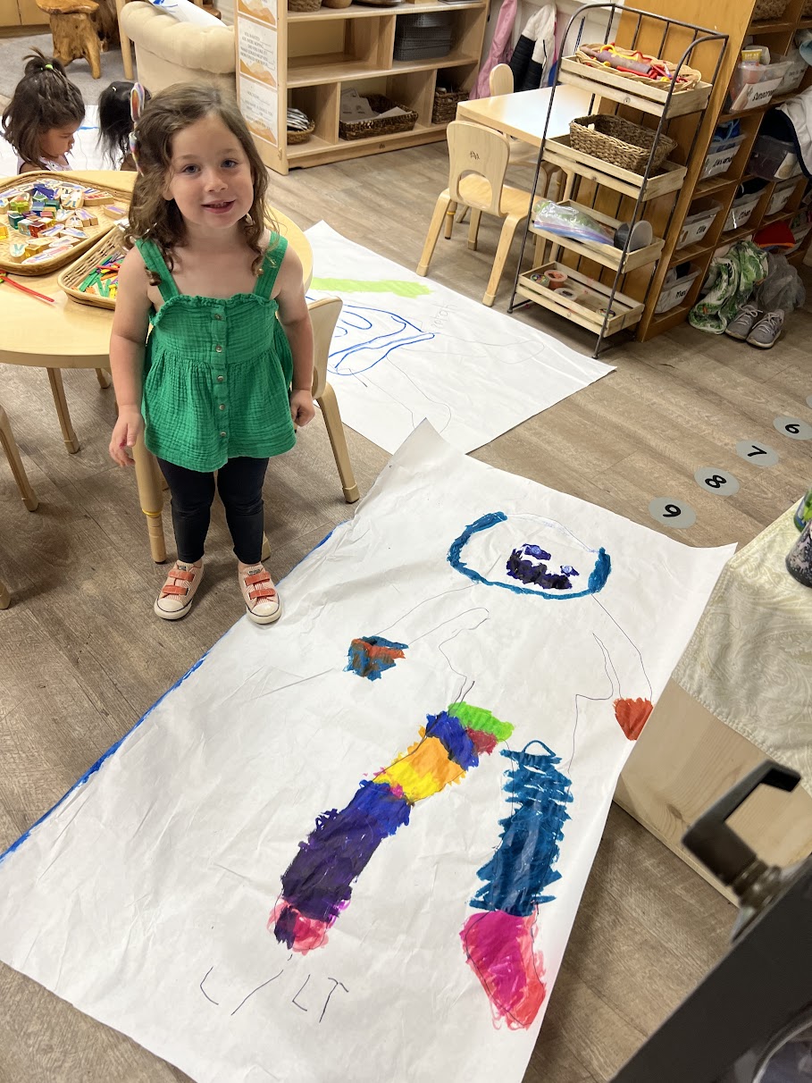 young girl with preschool artwork