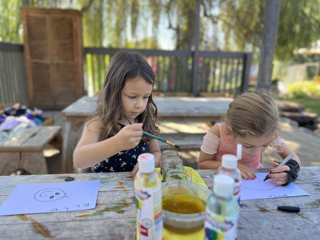 two girls painting outside