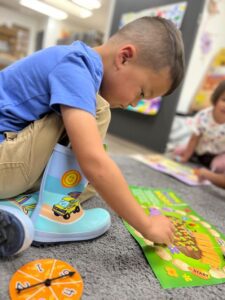 young boy playing board game at preschool