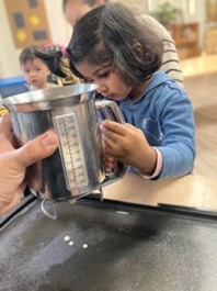measuring pancake batter at preschool