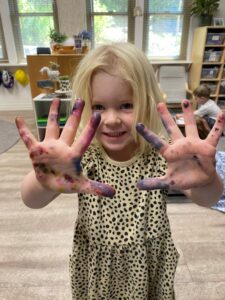 preschooler with paint on hands