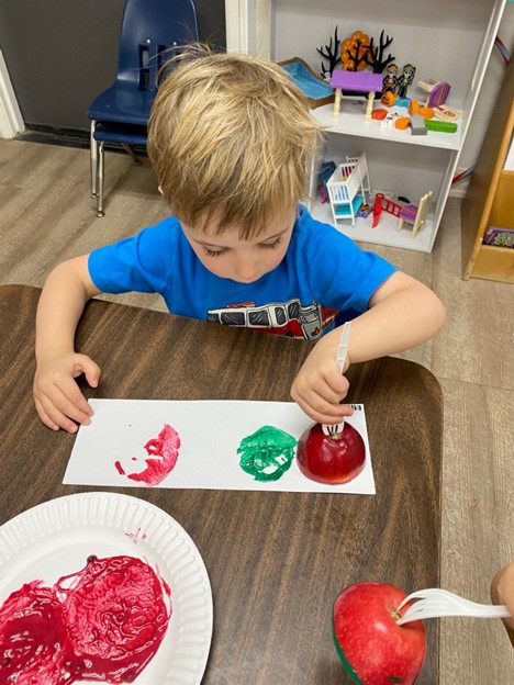 preschool boy with apple art